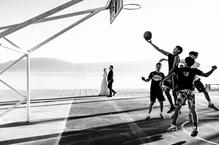 Black and white photo of the couple and guests jumping on the beach