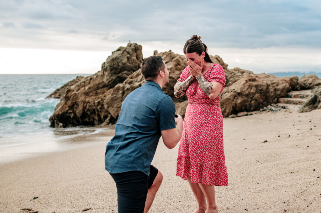 Man proposing on one knee on the beach