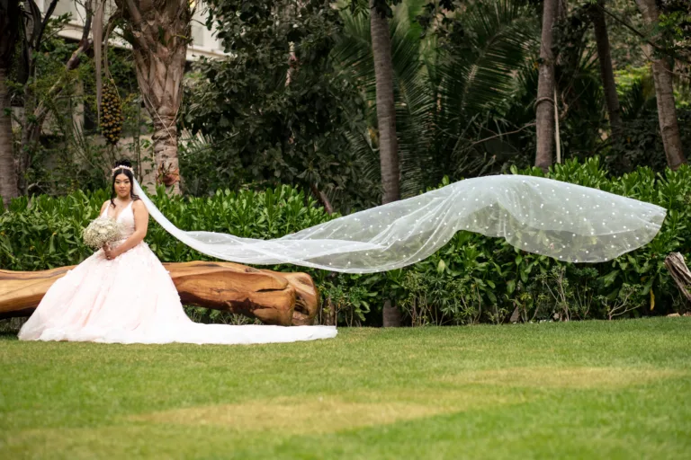 Bride's long veil flowing across a green lawn