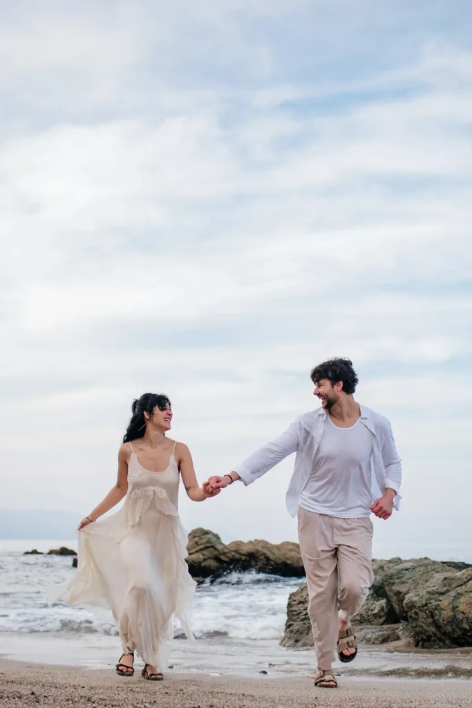 Couple walking hand in hand along the shore